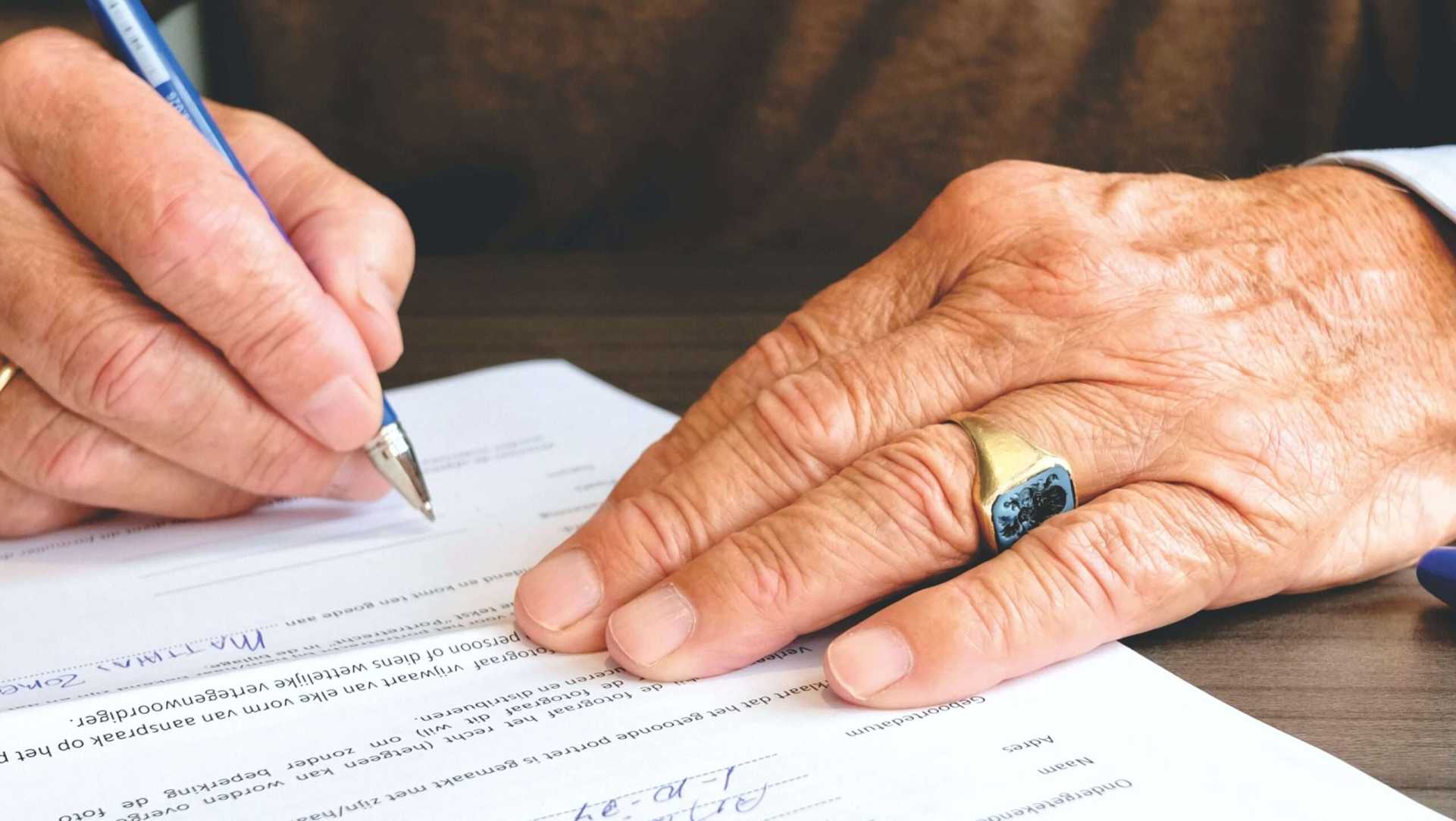 Persona firmando una póliza de cumplimiento